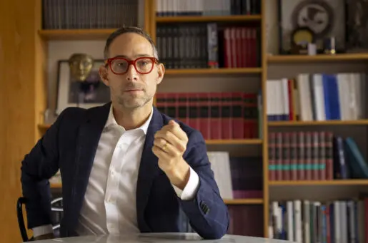 middle aged white man in front of bookcase