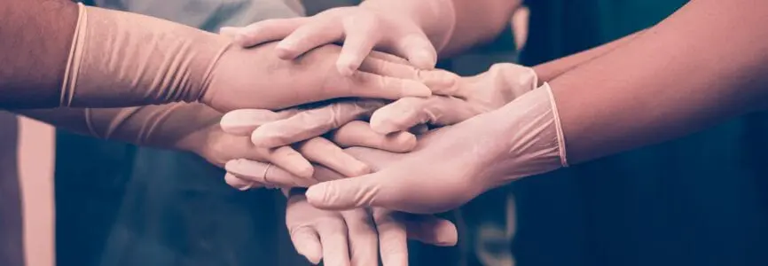 gloved hands holding each other