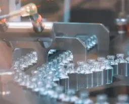 Glass bottles in production in the tray of an automatic liquid dispenser, a line for filling medicines against bacteria and viruses, antibiotics and vaccines