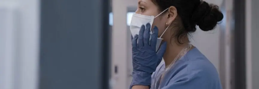 Nurse fixing surgical mask in infection room and preparing for treating corona virus.