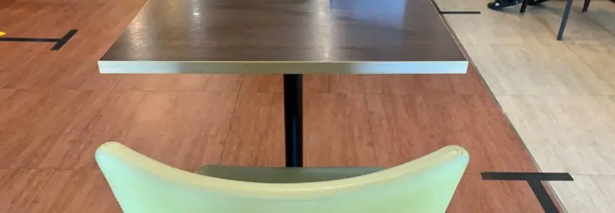 Red cross sign on dining table to make social distancing