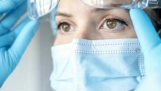 Doctor or researcher in a mask and protective goggles