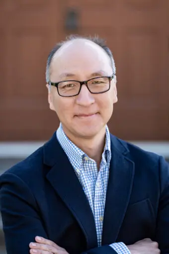 older asian man smiling, with glasses