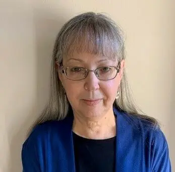 Older white woman with glasses smiling