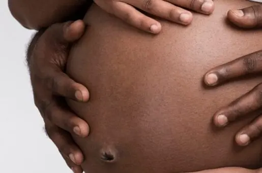 pregnant belly with hands holding it