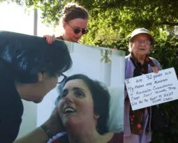 woman holding a photo of white woman in hospital bed