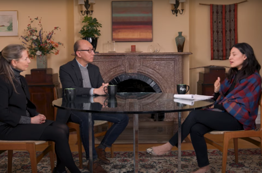 three people seated and talking, two woman with a man in middle