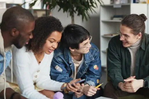 four people of color at a desk