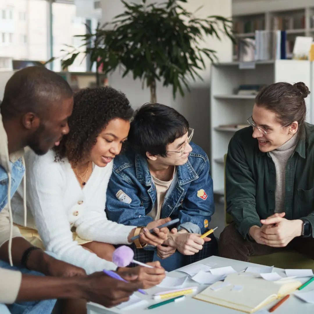 four people of color at a desk