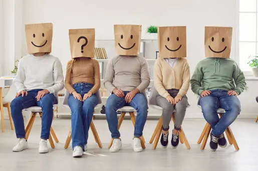 Group of unknown people with paper shopping package bags with emoticons on their heads