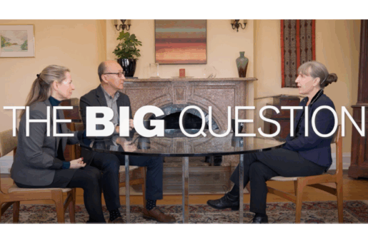 two white women talking to a balding asian man