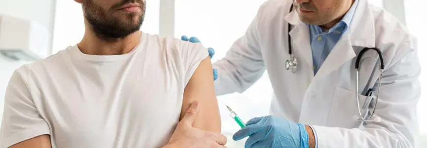 patient and doctor, with doctor holding needle to patient arm