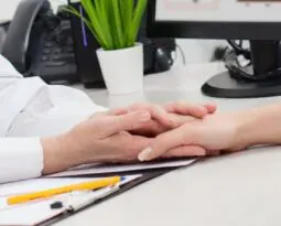 older pair of hands holding a young hand