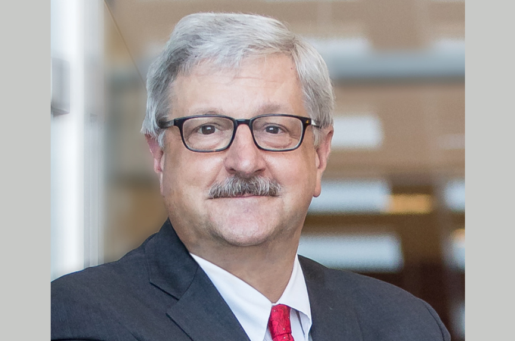 older white man with white hair and glasses