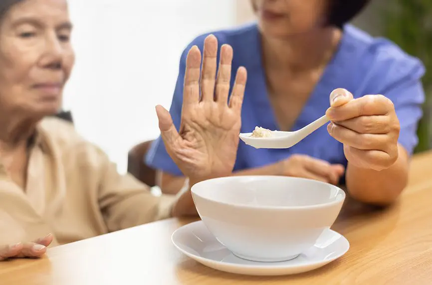 Senior asian woman bored with food.
