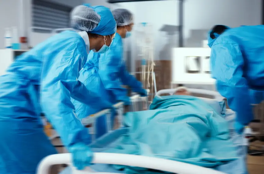 Women, man and hospital bed in motion blur of emergency surgery, healthcare wellness or risk condition operation. Doctors, nurses and medical workers with patient in busy er, theatre room or teamwork