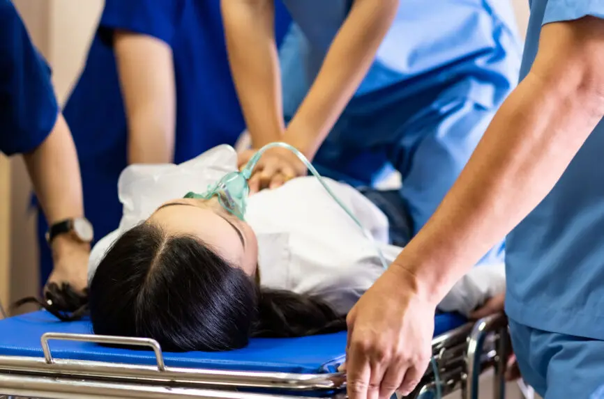 Panoramic Close up Medical team do CPR to seriously injured patient with oxygen mask while push gurney stretcher bed to Operating Room. Emergency health care and medical hospital concept.