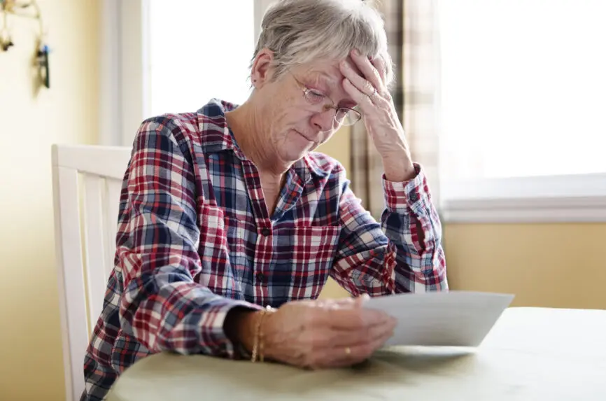 A Elderly woman worry about bill notice at home