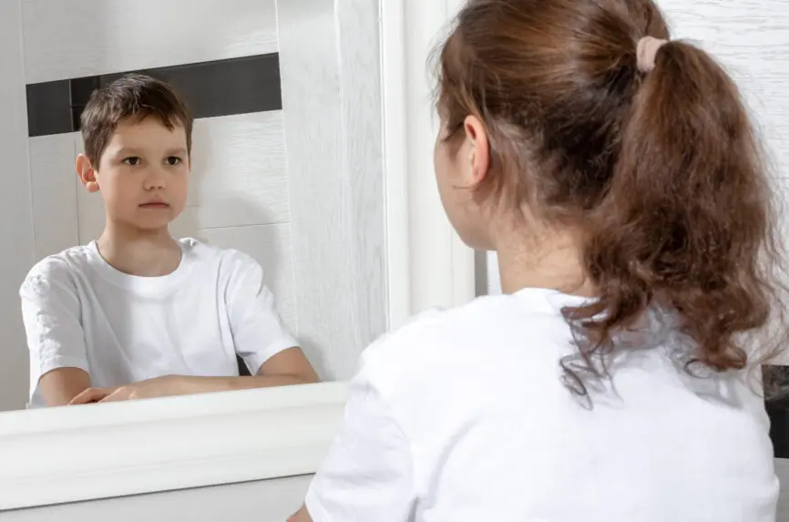 a girl looking in a mirror and seeing a boy