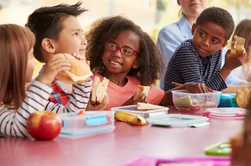 young school kids eating together