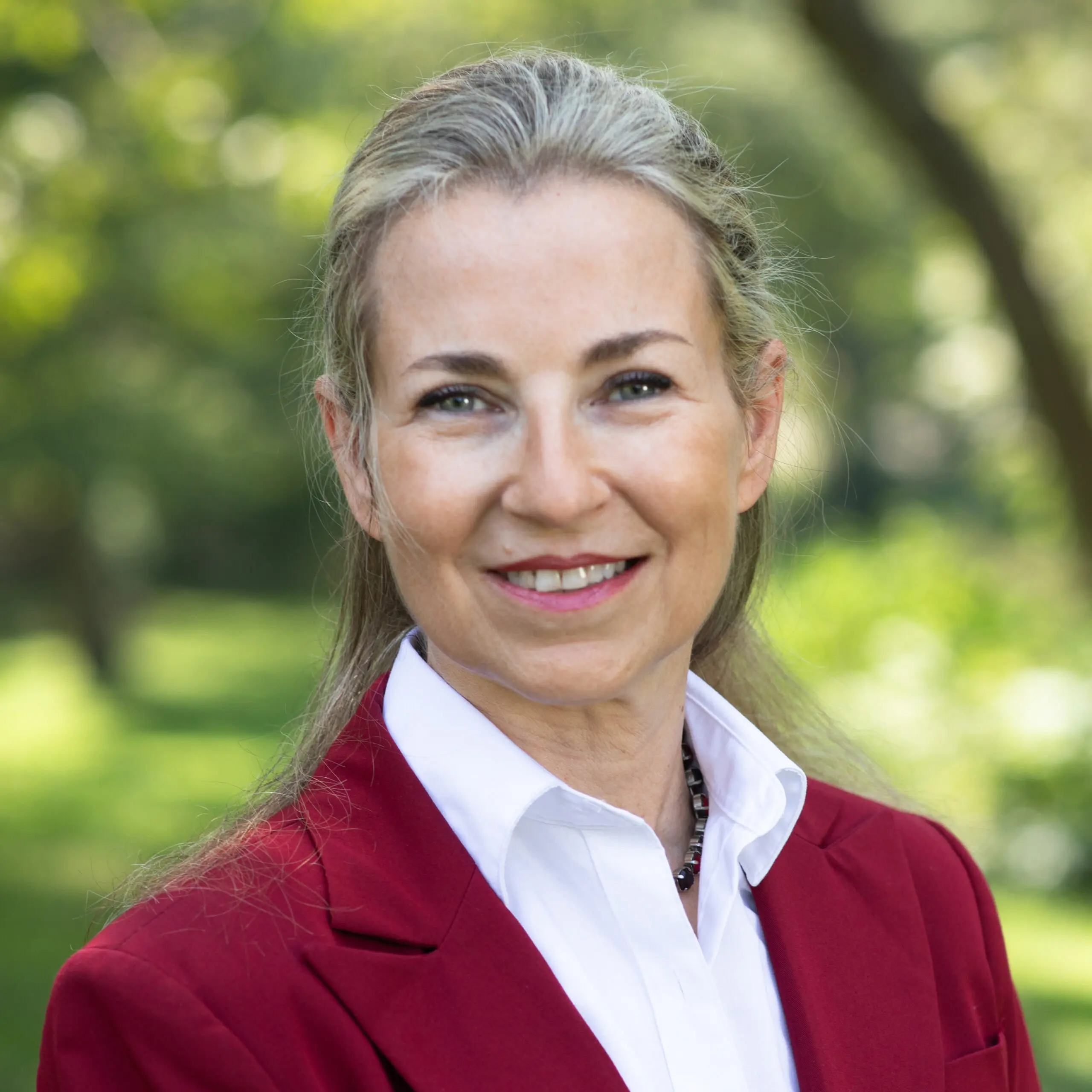 blond white woman in white shirt and red jacket