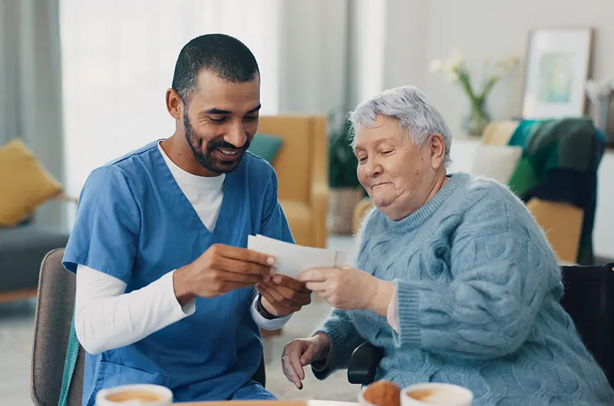 young man with beard, person of color, talking to older white woman with short hair