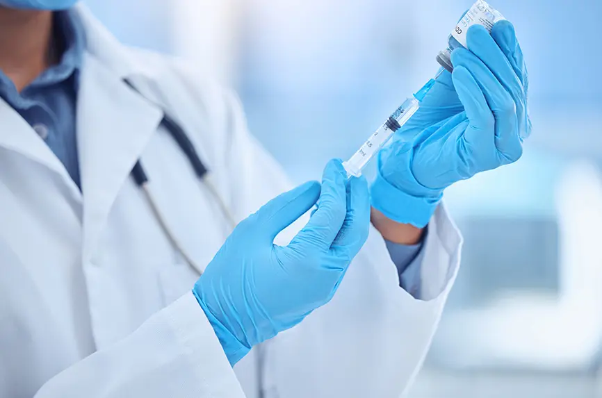 Gloves, test and doctor with medicine, syringe or preparing of vaccine, prevention or healthcare. Hospital, hands and injection for protection of flu, virus and person with dose, science and solution