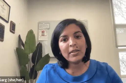 A black-haired woman talking into screen