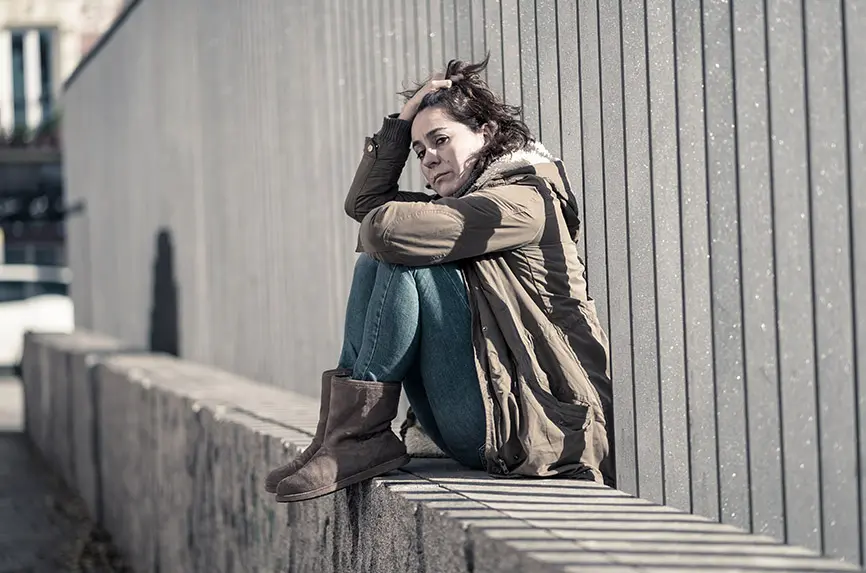 Young adult felling shame depressed and hopeless sitting alone in city urban street in Depression Loneliness Mental health Emotional pain Social violence Abusive relationship and Harassment concept.