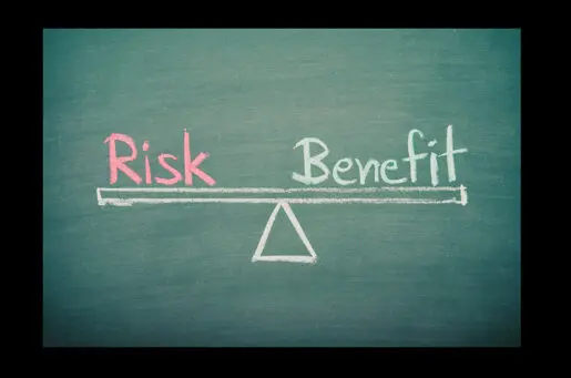 chalkboard with words risk and benefit written on a scale
