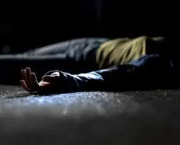 injured Black woman lying in the street at night