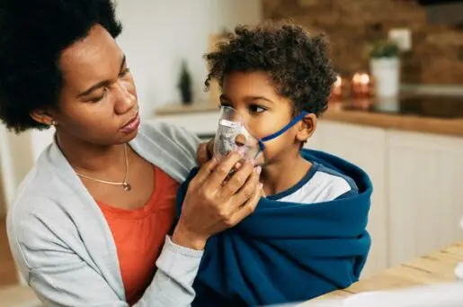 mom holding inhaler to child with asthma