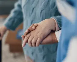 elderly person walking with help