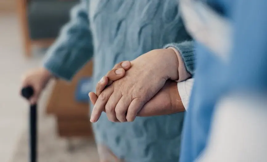 elderly person walking with help