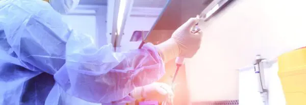 doctor using injection tube to put a bright light into a beaker