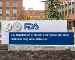 white sign in the ground with the letters FDA in blue