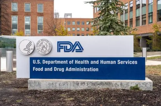 white sign in the ground with the letters FDA in blue