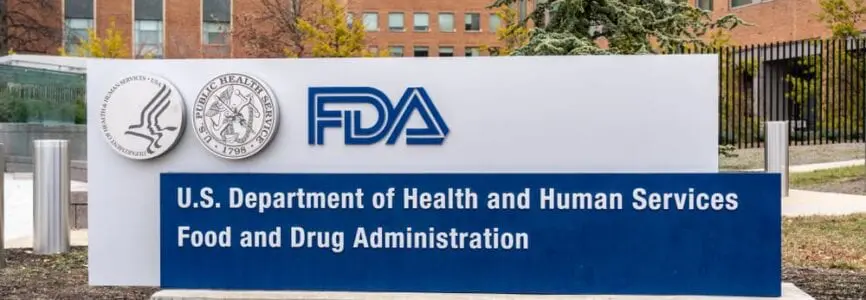 white sign in the ground with the letters FDA in blue