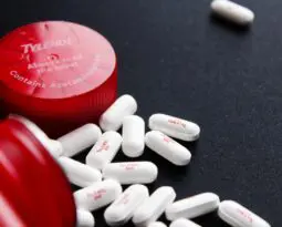 red bottle spilling white pills