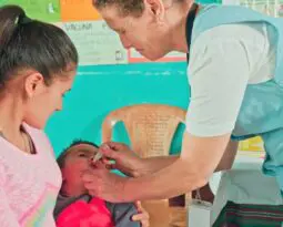 nurse giving baby vaccine by mouth