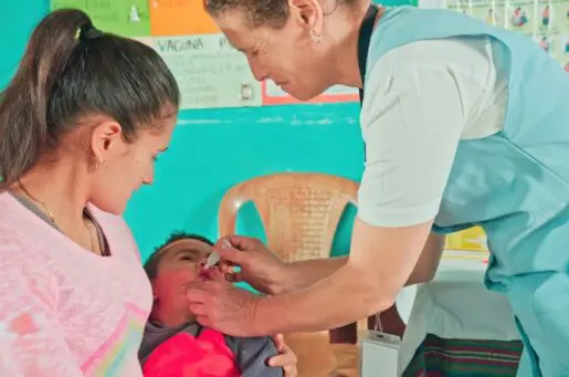 nurse giving baby vaccine by mouth