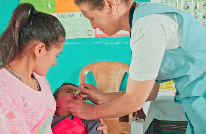 nurse giving baby vaccine by mouth