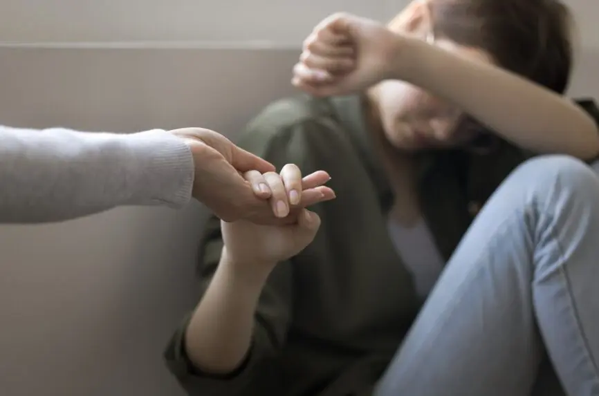 hand reaching out to depressed teenager
