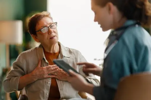 older white woman with glasses talking to a doctor with dark hair