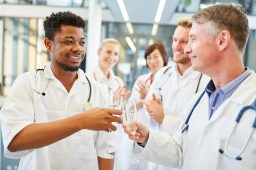 men in white coats toasting with alcohol