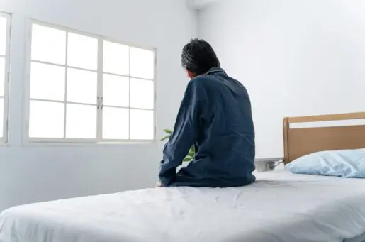 back of man on white bed in white room