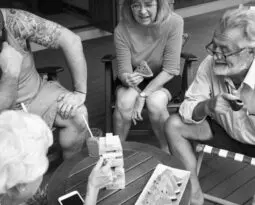 Black and white photo of older white people playing jenga game