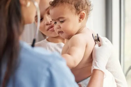 sick baby in nurse's arms