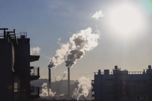 smokestacks next to apartment buildings