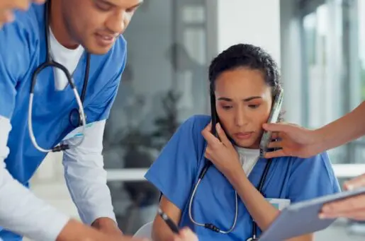 stressed clinicians with smartphone and computer